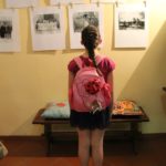 Una bambina ammira la mostra fotografica