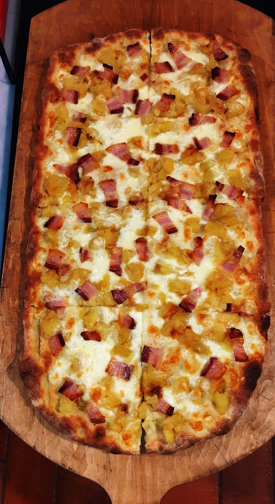 Pizza alla pala con cipolla stufata, taleggio e crudo croccante